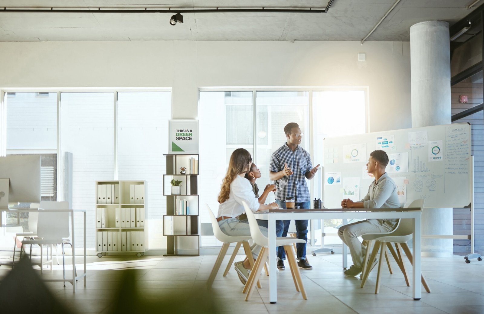 Group of diverse businesspeople having a meeting in an office at work. Young african american businessman talking while doing a presentation at a table for coworkers. Businesspeople planning together